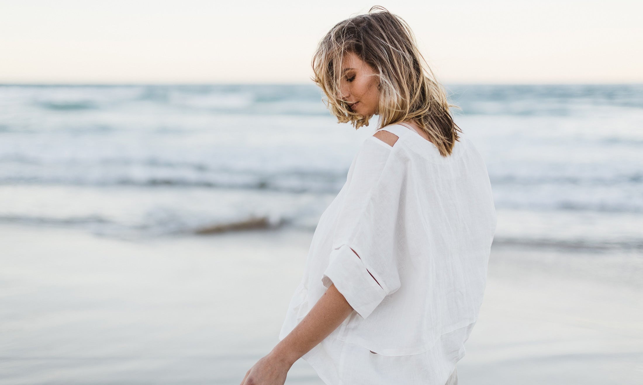 Love linen not wrinkles. Women wearing white linen top at the beach
