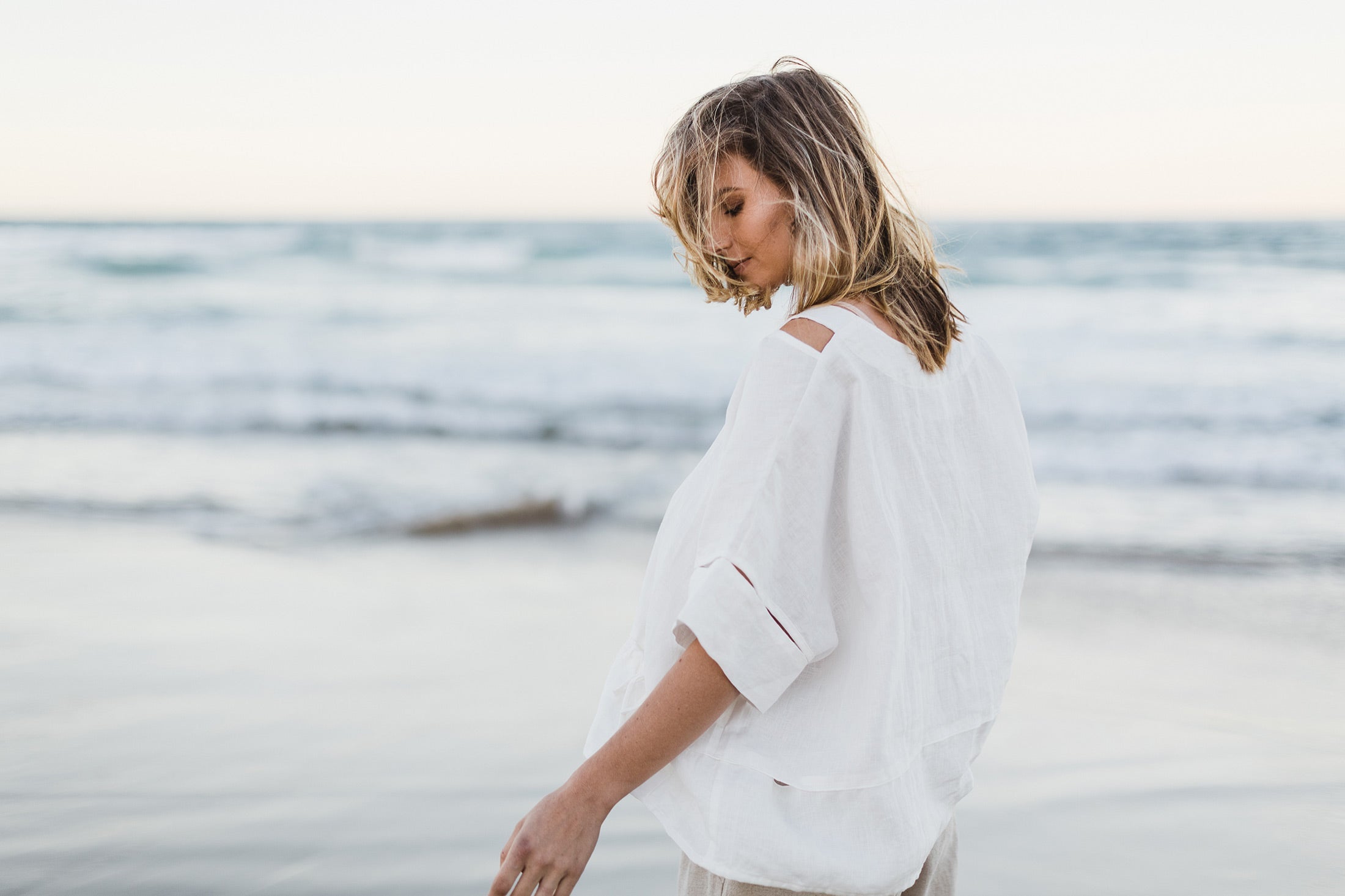 Love linen not wrinkles. Women wearing white linen top at the beach