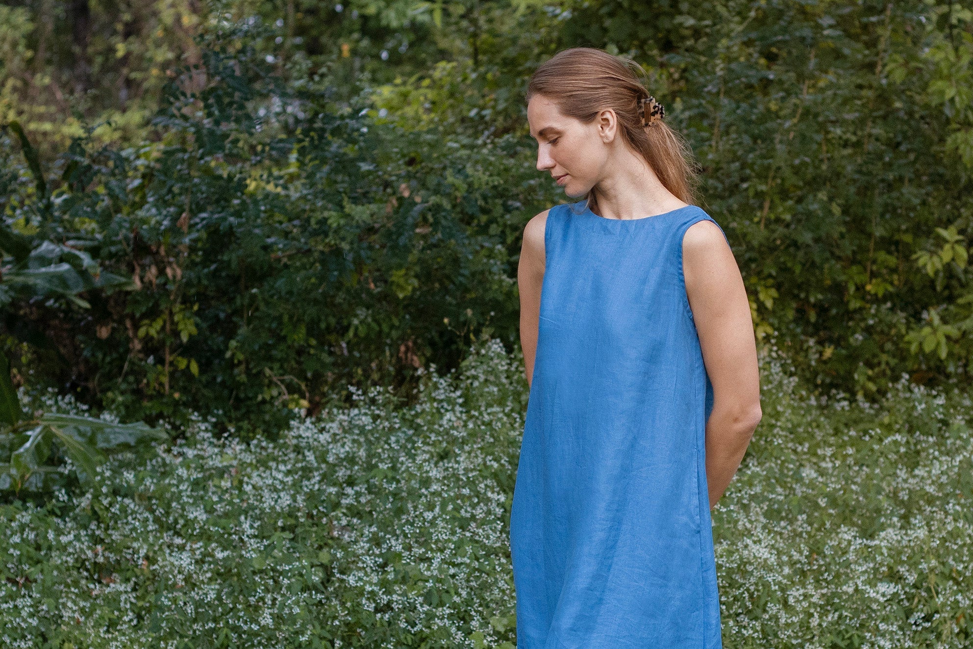 Soft blue coloured knee length linen dress without sleeves, v neck and waist tie detail