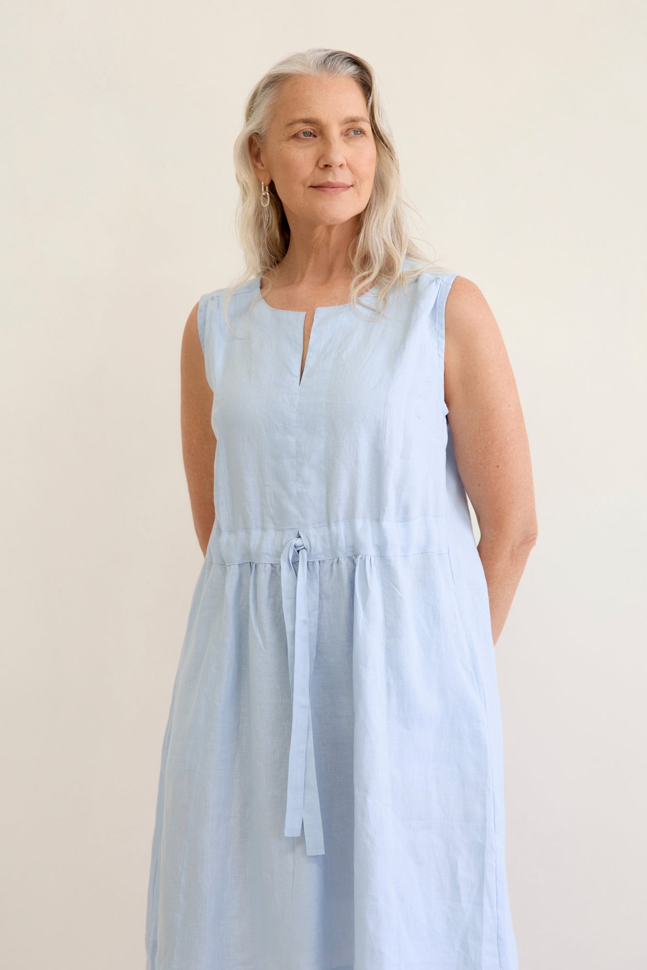 Natural coloured knee length linen dress with sleeves, v neck and waist tie detail