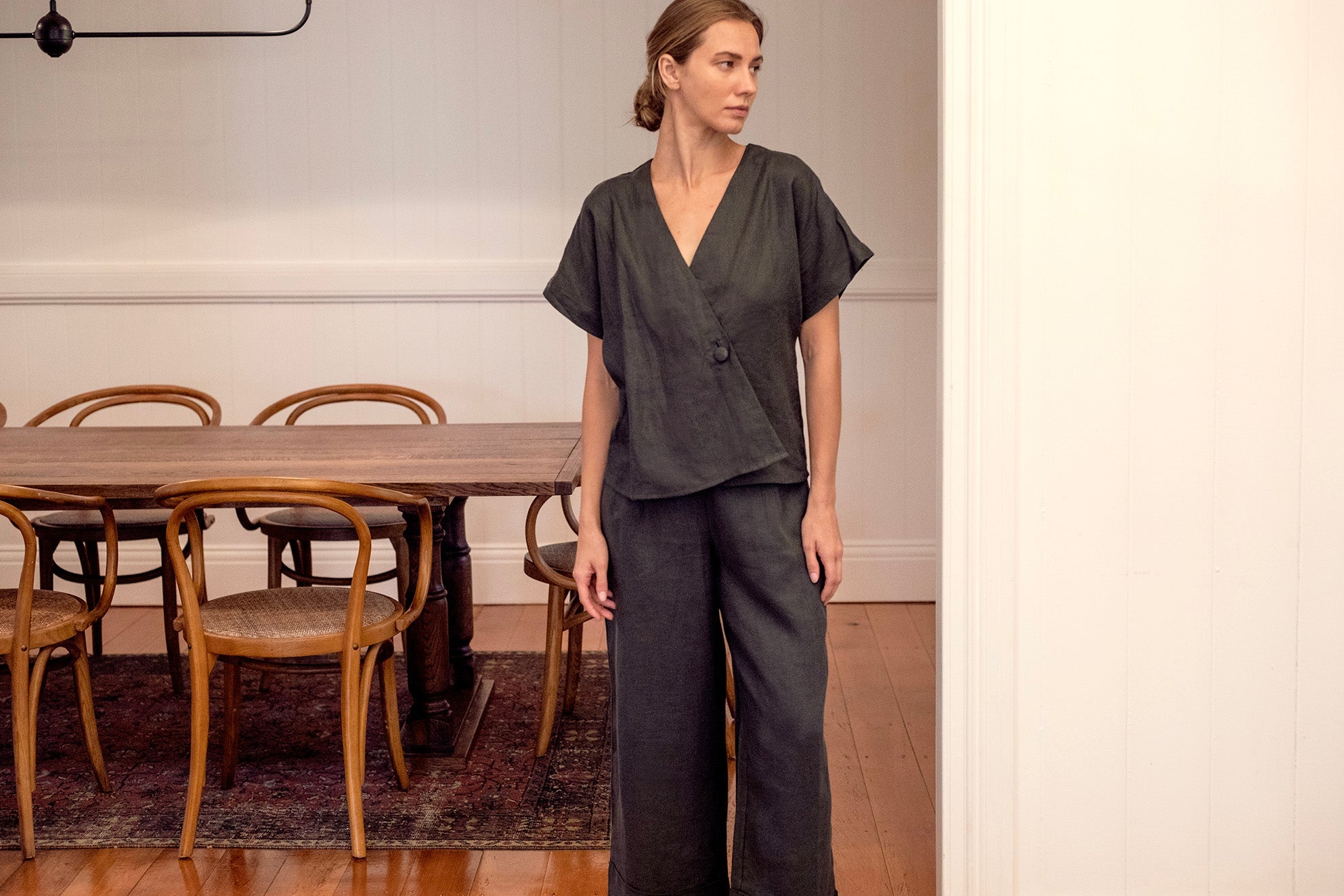 Charcoal coloured linen pants worn by women in casual setting with matching linen shirt