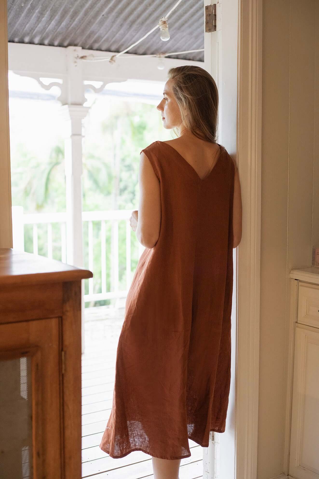 Woman wearing a Cynthia Linen Dress Bark, showcasing its versatile and elegant design.