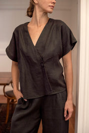 Woman wearing a charcoal linen top and pants in an indoor setting
