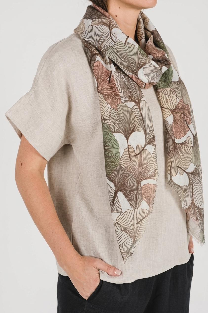 Model wearing an Autumn Gingko Scarf featuring a gingko leaf print in warm autumn hues.