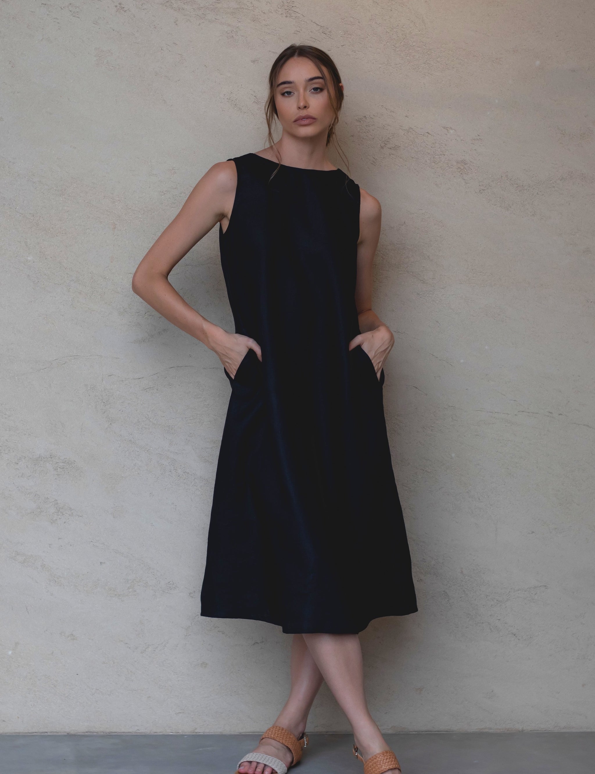 Woman wears Cynthia linen dress black with boat neck displaying just one of the many styling options